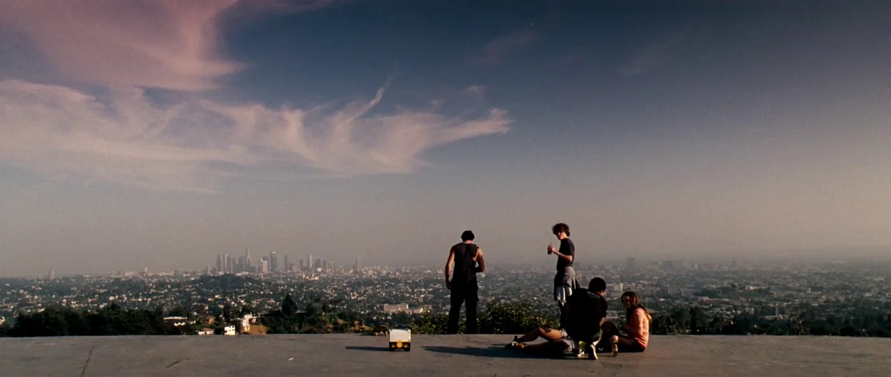 Little Birds (2011) movie still: wide — A high concrete ledge provides a panoramic view of the Los Angeles sprawling city. Five individuals stand or…