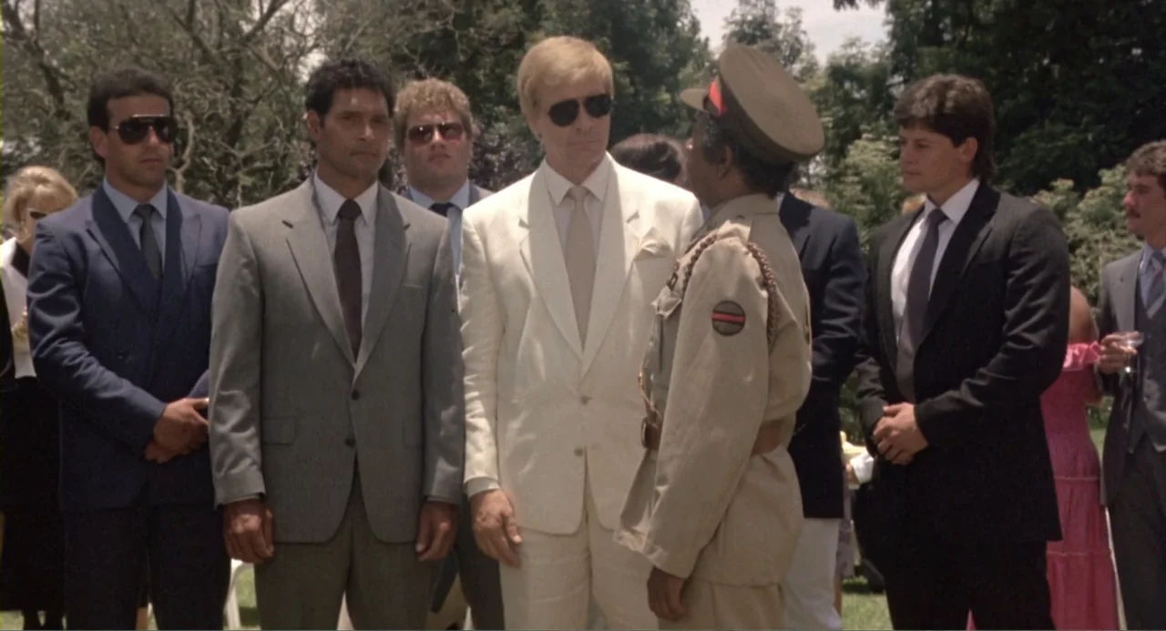 American Ninja 2: The Confrontation (1987) movie still: fullbody — An outdoor social event features several men in business suits and a military…