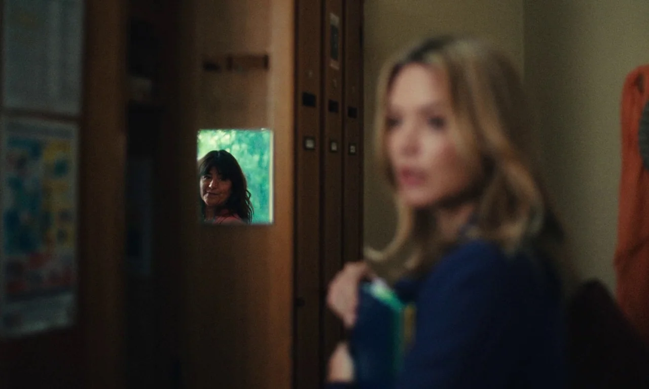 Just The Two Of Us (2023) movie still: medium — A locker room interior features tall wooden lockers with a small square mirror attached. A woman…