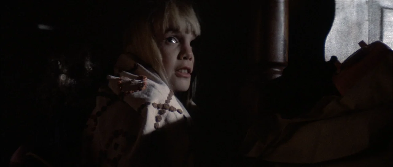 Poltergeist II: The Other Side (1986) movie still: closeup — A dark, dimly lit bedroom at night with a person partially hidden in shadow. A child…
