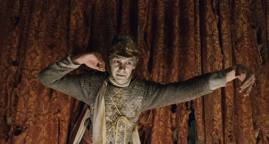 The Imaginarium of Doctor Parnassus (2009) movie still: medium — A dark tent interior features heavily weathered and tattered damask curtains as a…