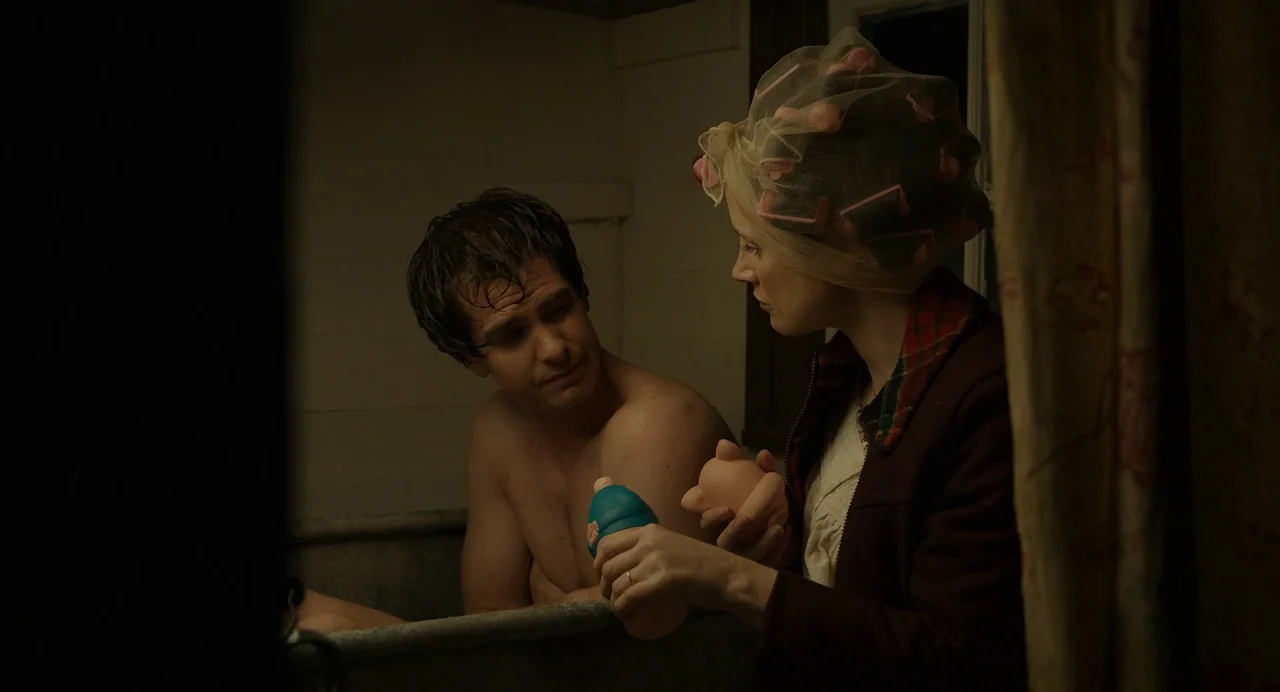 The Eyes of Tammy Faye (2021) movie still: medium — A dimly lit room with wood-paneled walls features a porcelain bathtub. A woman in a hairnet…