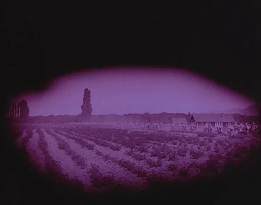Birth of a Nation (1915) movie still: establishing — A rural landscape shows rows of crops extending toward a distant farmhouse and trees. Riders on…