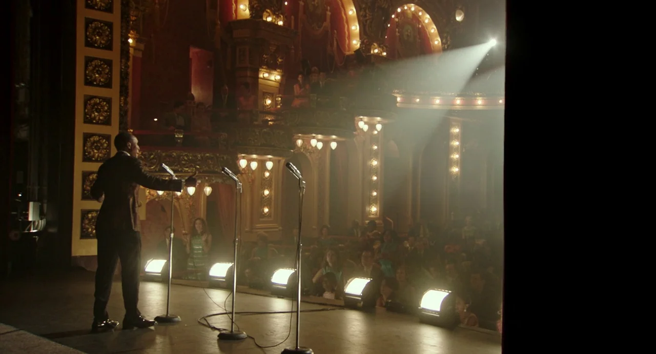 Detroit (2017) movie still: fullbody — An ornately decorated 1960s theater auditorium features gold-leaf wall panels and private balcony boxes. A…
