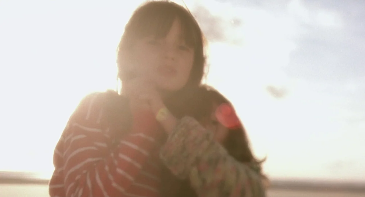 The Diving Bell and the Butterfly (2007) movie still: medium — Two children stand together against a bright, hazy sky on an open beach. The sun…