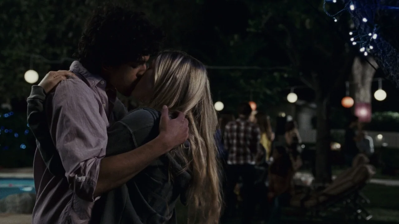 The Kids Are All Right (2010) movie still: medium — A dark backyard at night is illuminated by several strings of hanging paper lanterns. A teenage…