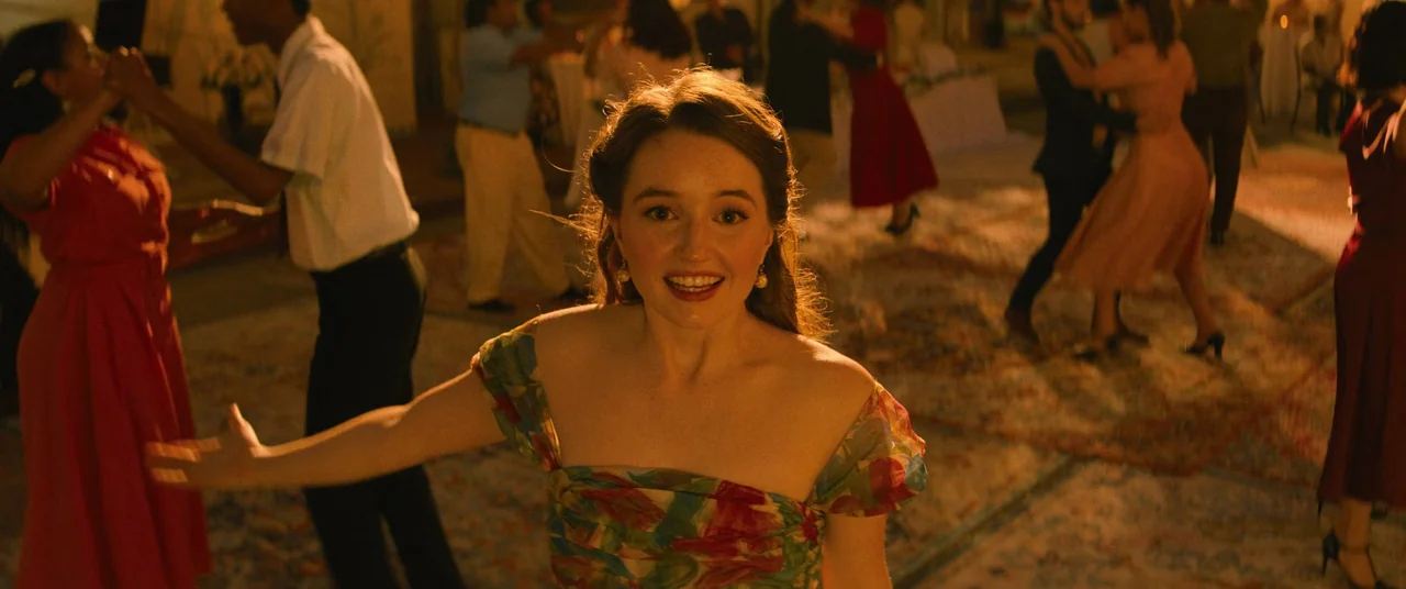 No One Will Save You (2023) movie still: medium — An outdoor dance party features couples dancing on an open area with patterned rugs. A young woman…