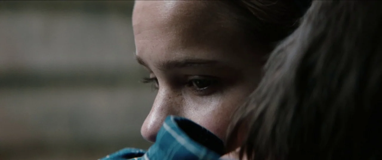 Good Favour (2017) movie still: closeup — A close view of a woman's face resting against another person's shoulder. The background is out of focus…