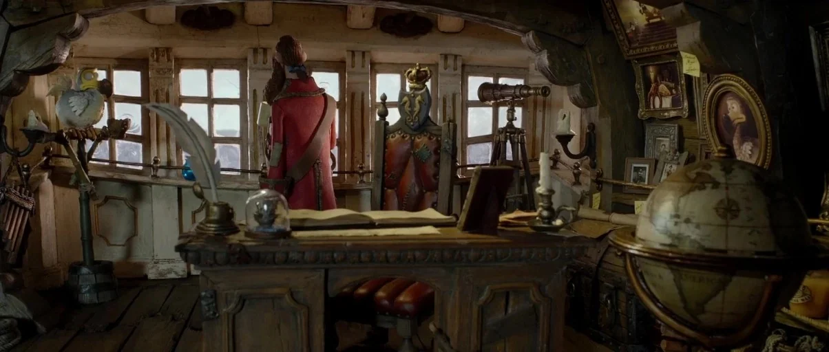 The Pirates! Band of Misfits (2012) movie still: wide — A cluttered ship captain's quarters features a large wooden desk with nautical navigation…