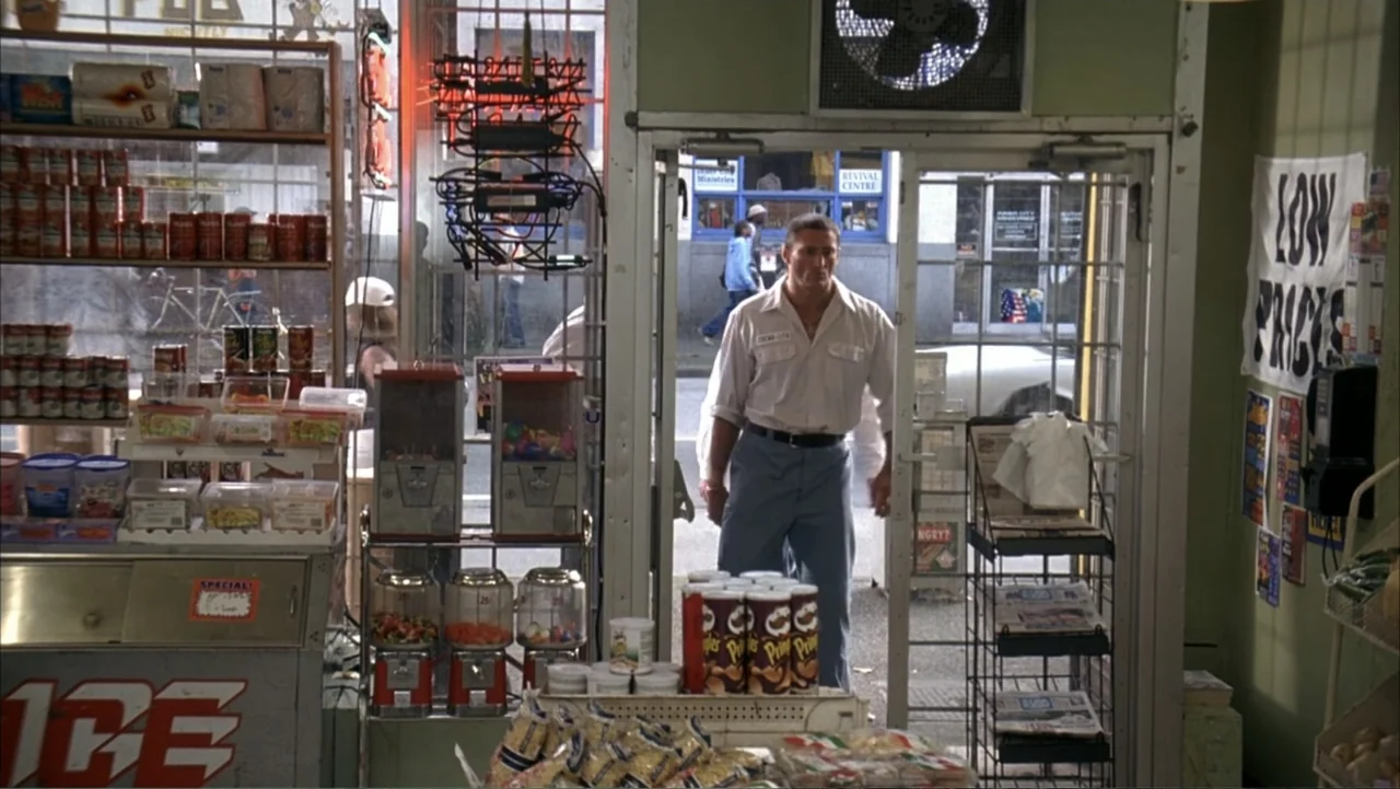 White Chicks (2004) movie still: fullbody — A cluttered convenience store interior features rows of products and glass display counters. A man…