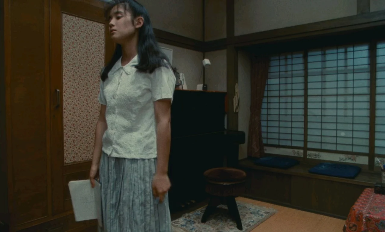 Chizuko’s Younger Sister (1991) movie still: medium — A traditional Japanese room features dark wood trim, shoji window screens, and a black piano.…
