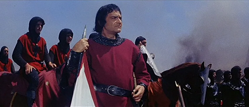 Erik The Conqueror (1961) movie still: medium — A field filled with armed men on horseback under a clear, bright sky. A central figure in a red…