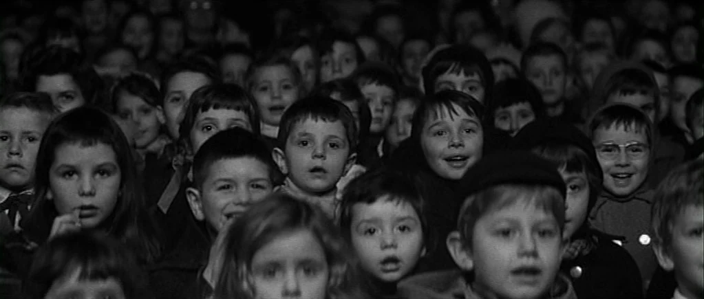 The 400 Blows (1959) movie still: medium — A dense crowd of young children seated closely together in a dark theater. They stare forward with…