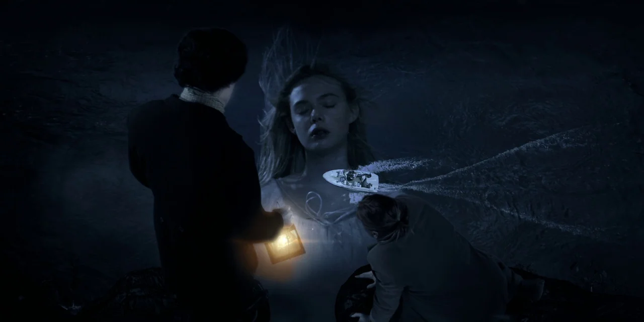 Twixt (2011) movie still: wide — A dark, expansive body of water contains a giant superimposed image of a woman. Two figures in the foreground hold…