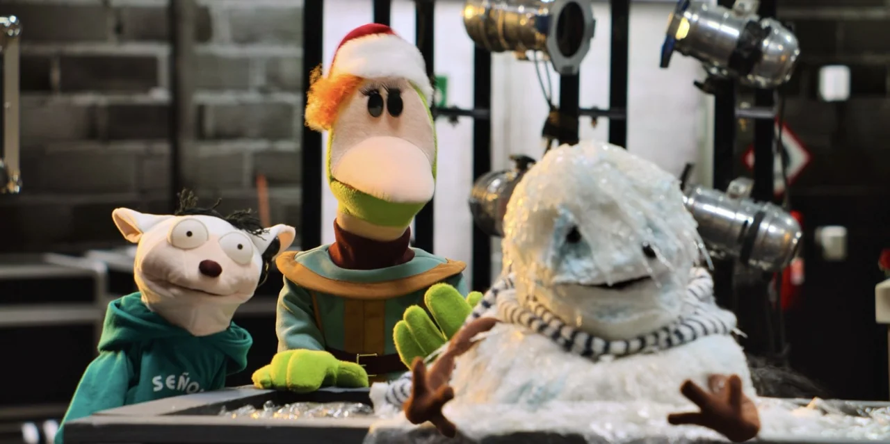 31 Minutes: One Hot Christmas (2025) movie still: medium — A television studio setting features three distinct hand puppets positioned on a…