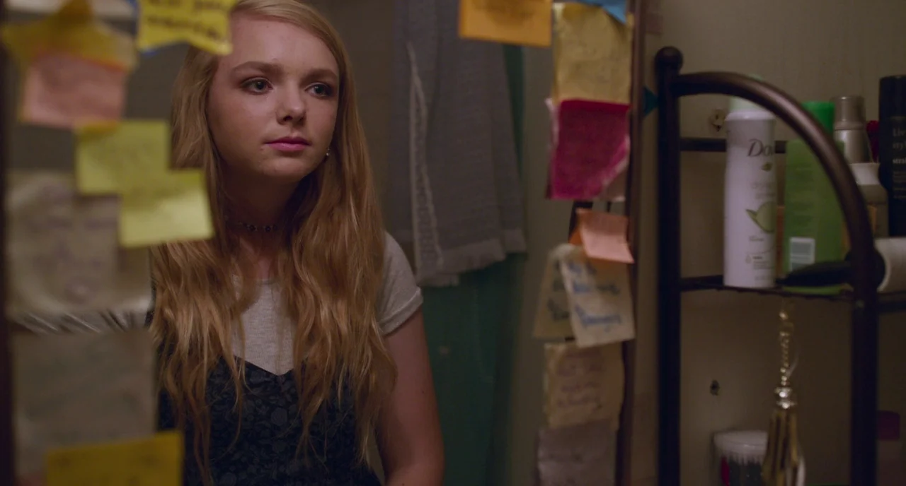 Eighth Grade (2018) movie still: medium — A bathroom mirror is covered with various yellow adhesive notes and writing. A young woman with blonde…