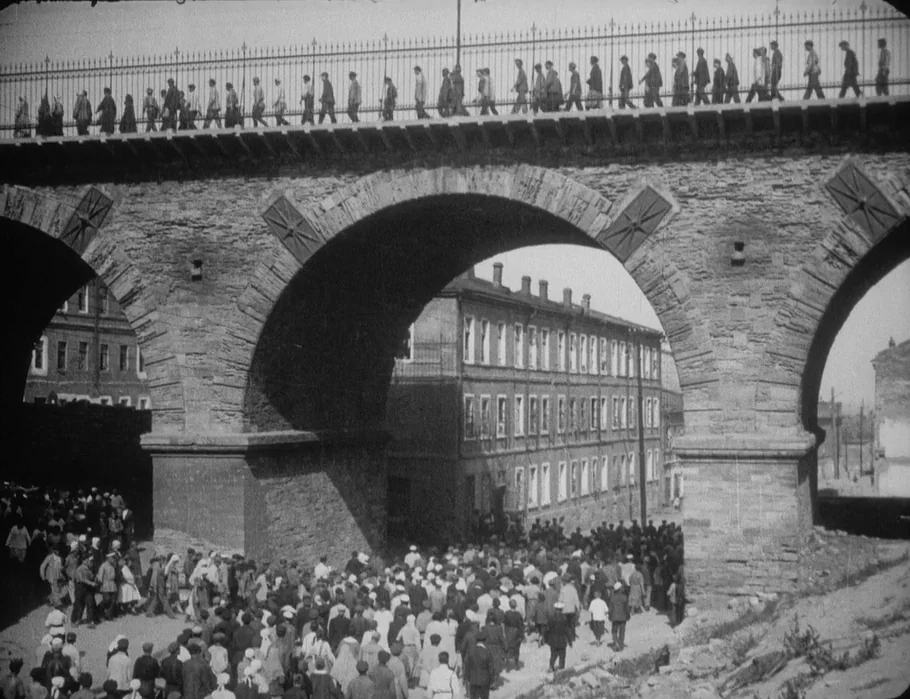Battleship Potemkin (1925) movie still: wide — A massive stone viaduct with large arched supports dominates the frame. A large group of people…