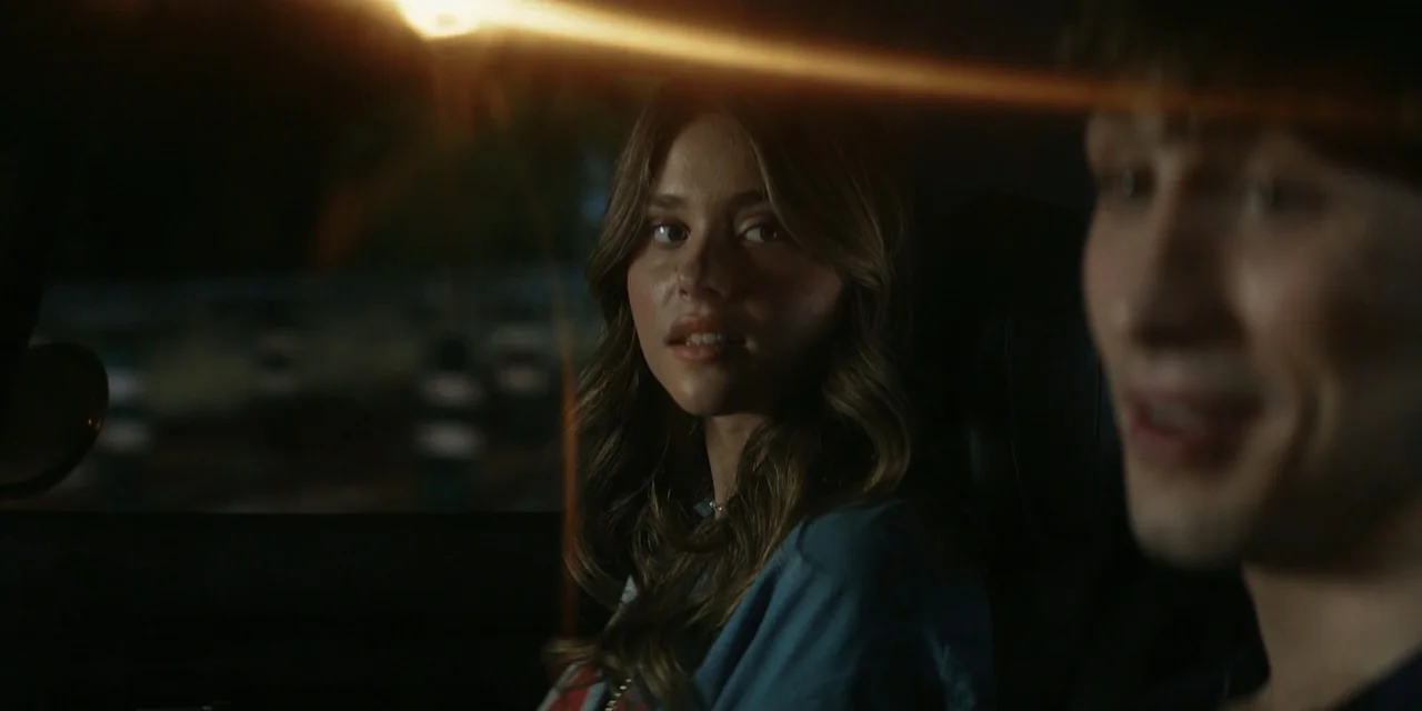 My Fault (2023) movie still: medium — The interior of a moving vehicle at night with dark exterior surroundings visible through windows. A woman in…