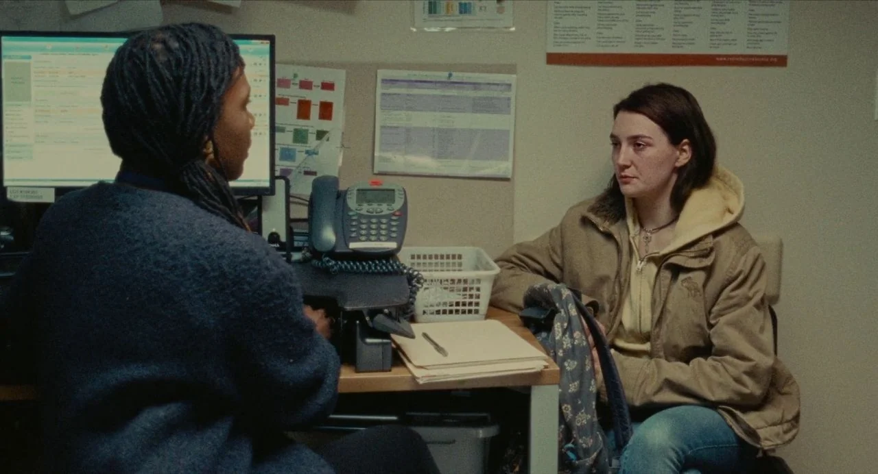 Never Rarely Sometimes Always (2020) movie still: medium — A cramped administrative office features papers and forms pinned to a beige wall. A young…