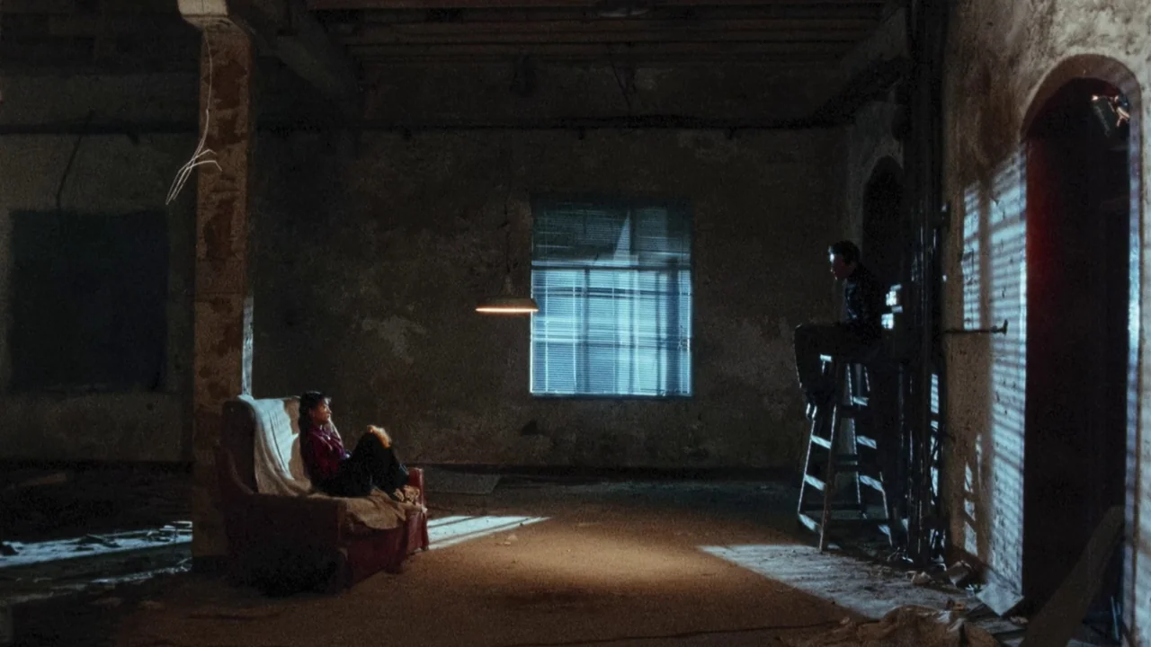 Suzhou River (2000) movie still: wide — A spacious, derelict room features peeling walls and an industrial aesthetic with exposed concrete beams. A…