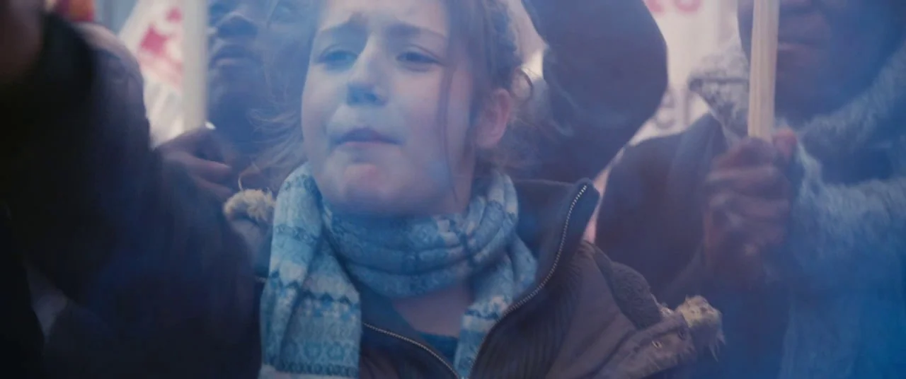 Blue Is The Warmest Colour (2013) movie still: closeup — A group of people are gathered together in an outdoor public space during daytime. A young…
