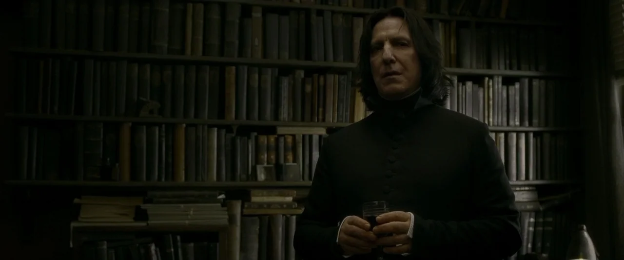 Harry Potter & The Half Blood Prince (2009) movie still: medium — A dark, dimly lit library with floor-to-ceiling shelves packed with aged,…