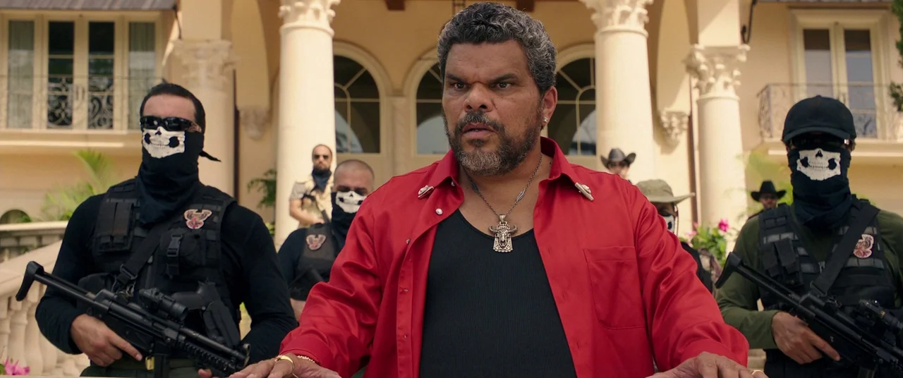 Keanu (2016) movie still: medium — A group of armed men in tactical gear stand before a large classical villa. An older man in a red shirt stands…