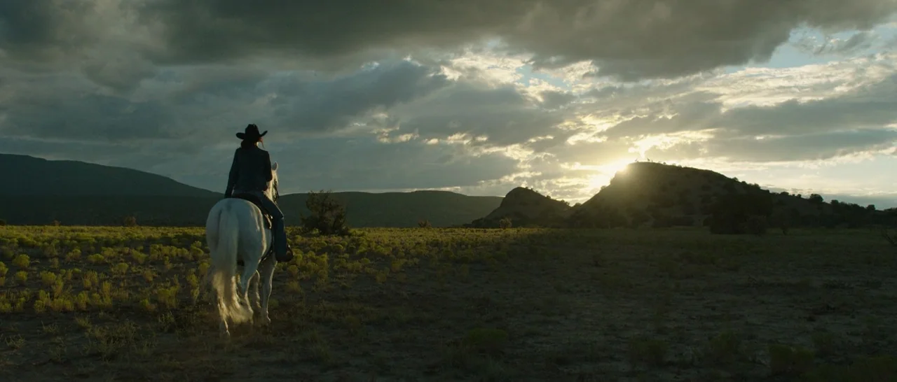 Only The Brave (2017) movie still: wide — A vast, open plain stretches toward silhouetted mountain ridges under a heavy, clouded sky. A lone rider…