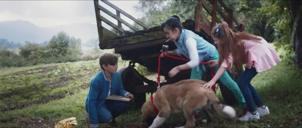Loving is Losing (2019) movie still: fullbody — A rustic farm landscape features a large wooden cart parked in a grassy field. Three children play…