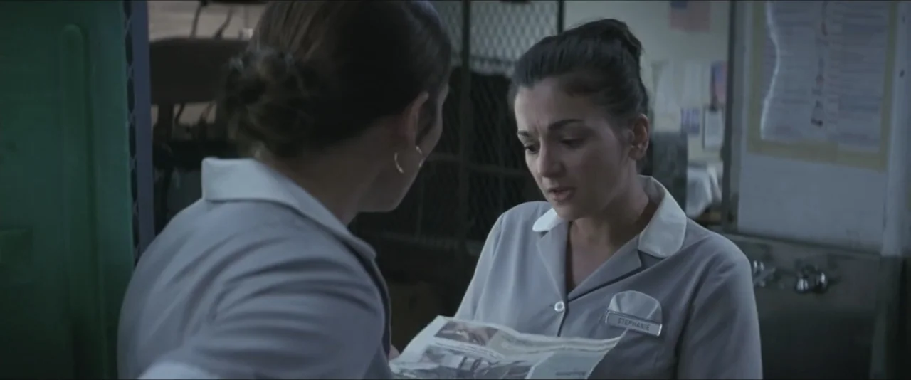 Maid in Manhattan (2002) movie still: medium — A utilitarian room with metal lockers and a tiled wall backdrop. Two women wearing service uniforms…