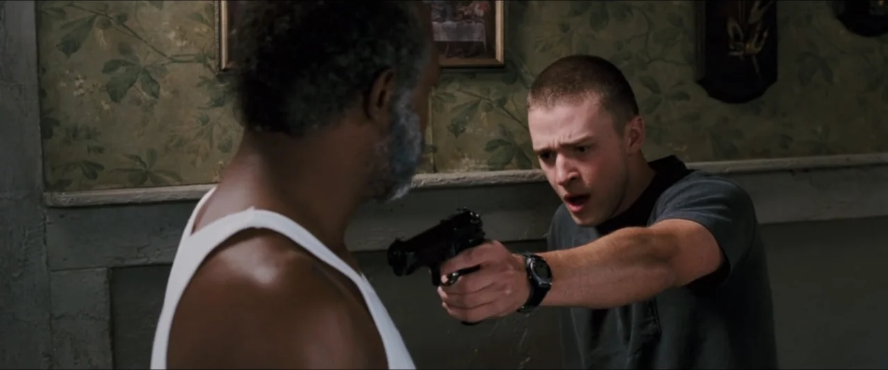 Black Snake Moan (2006) movie still: medium — An interior hallway features patterned floral wallpaper and a framed picture on the wall. A man points…