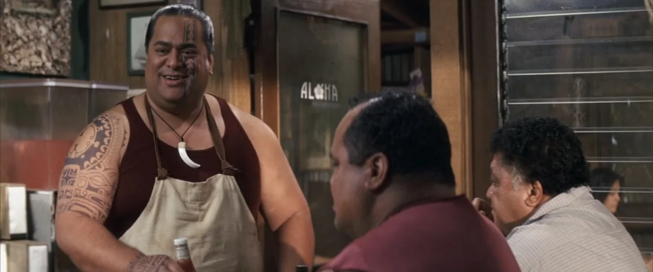 50 First Dates (2004) movie still: medium — A wooden building interior features an Aloha sign on a glass door.