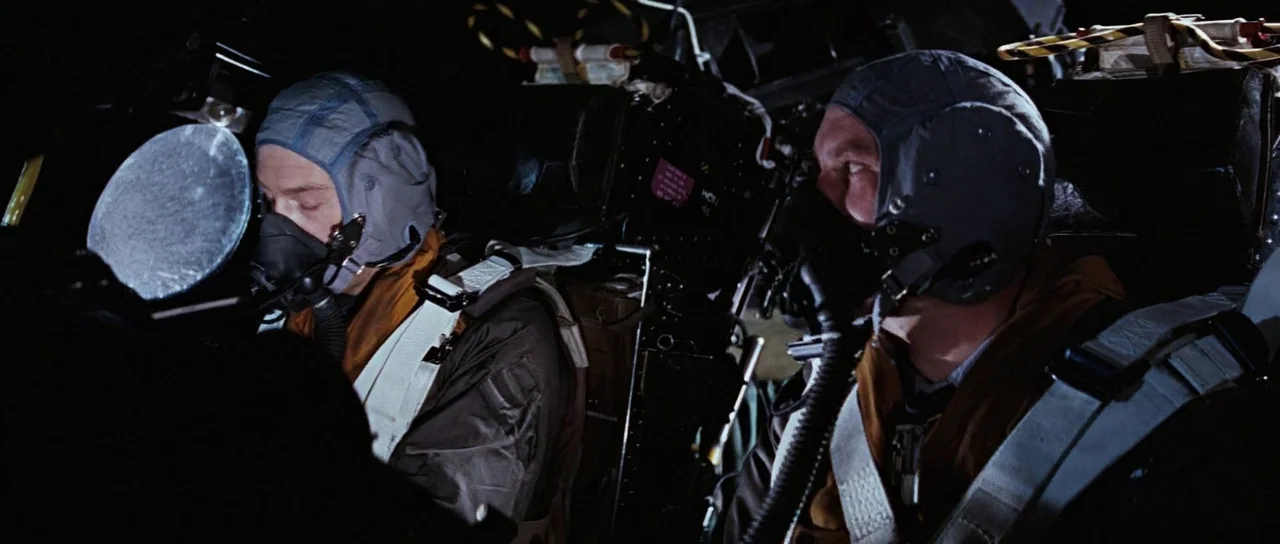 Thunderball (1965) movie still: medium — The cramped interior of a military aircraft cockpit features complex instrumentation and machinery. Two…