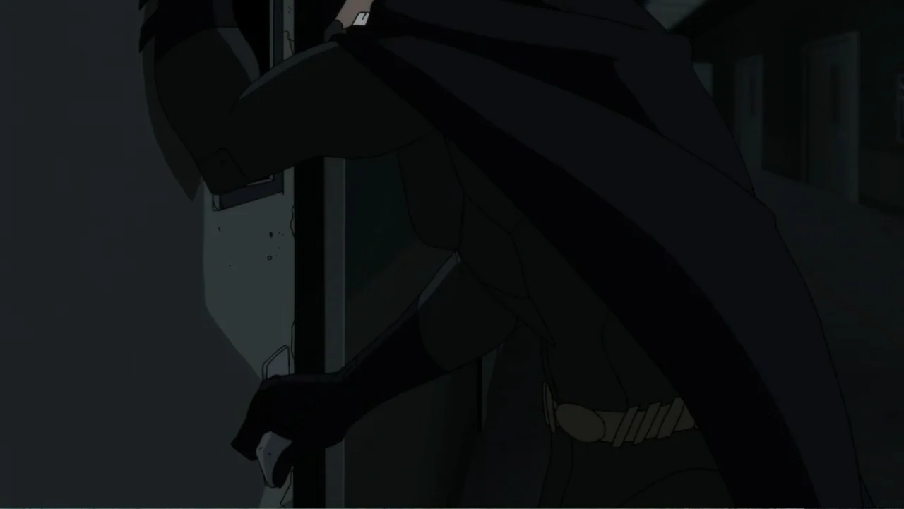 Justice League Dark (2017) movie still: medium — A dark hallway with smooth walls and a heavy door in the foreground. A caped figure in a tactical…