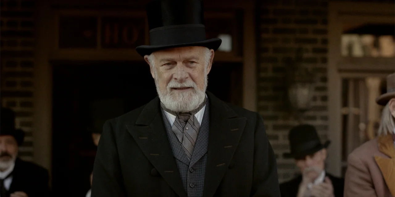 Deadwood: The Movie (2019) movie still: medium — An outdoor town setting featuring brick architecture during the late nineteenth century. An elderly…