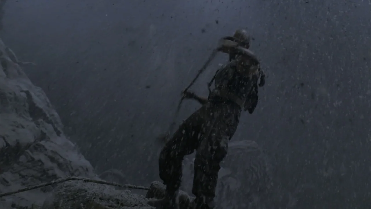 The Chronicles of Riddick (2004) movie still: medium — A rugged snow-covered mountain face is obscured by swirling wind and heavy falling snow. A…