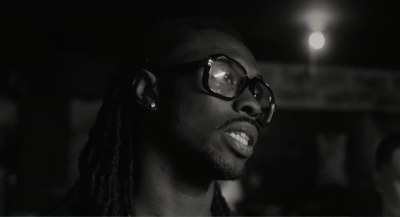 What You Gonna Do When the World's on Fire? (2019) movie still: closeup — A dimly lit interior space with a dark, blurred background and a distant…