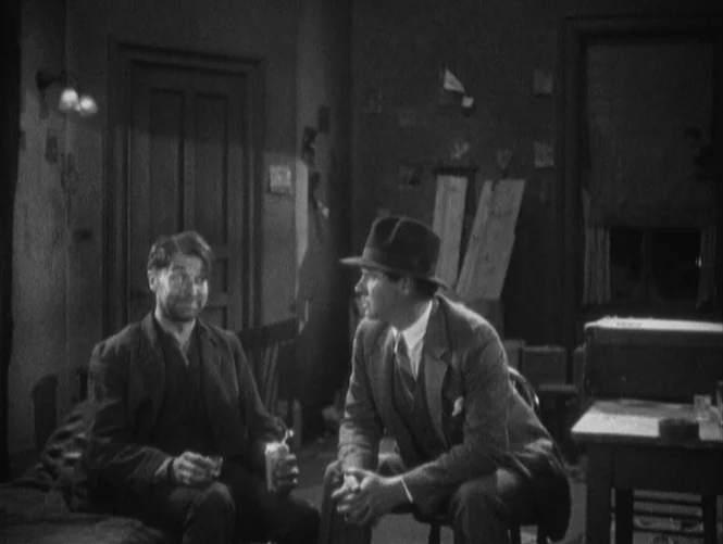 Underworld (1927) movie still: medium — A dimly lit room with walls decorated with small papers and a wooden table. Two men sit in the room engaged…