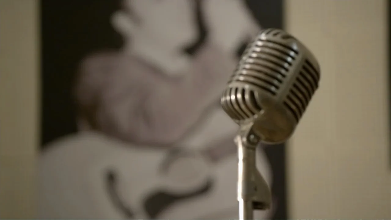 The Day the Music Died: The Story of Don McLean's "American Pie" (2022) movie still: closeup — A close-up of a vintage silver microphone stands…