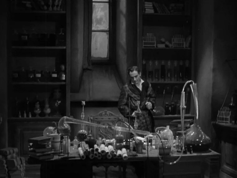 Dr. Jekyll and Mr. Hyde (1931) movie still: medium — A cluttered 1930s laboratory features tall shelves filled with glass bottles and jars. A lone…