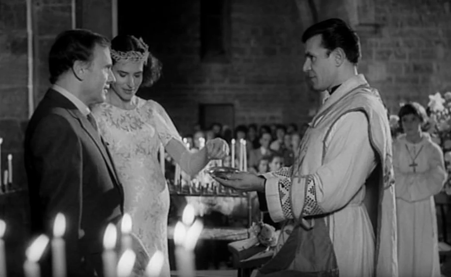 Vivement Dimanche (1983) movie still: medium — A stone church interior with blurred congregants visible in the dark background. A woman in a lace…