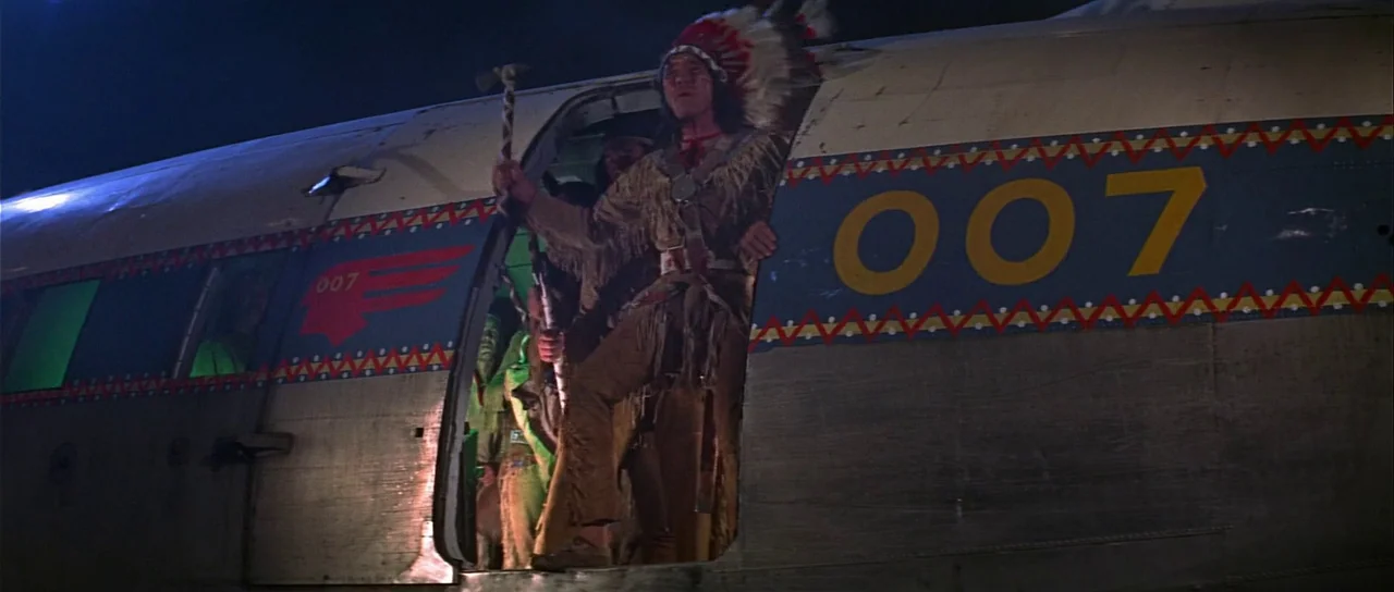 Casino Royale (1967) (1967) movie still: medium — A metallic airplane exterior with a '007' marking on the fuselage at night. A man dressed in…