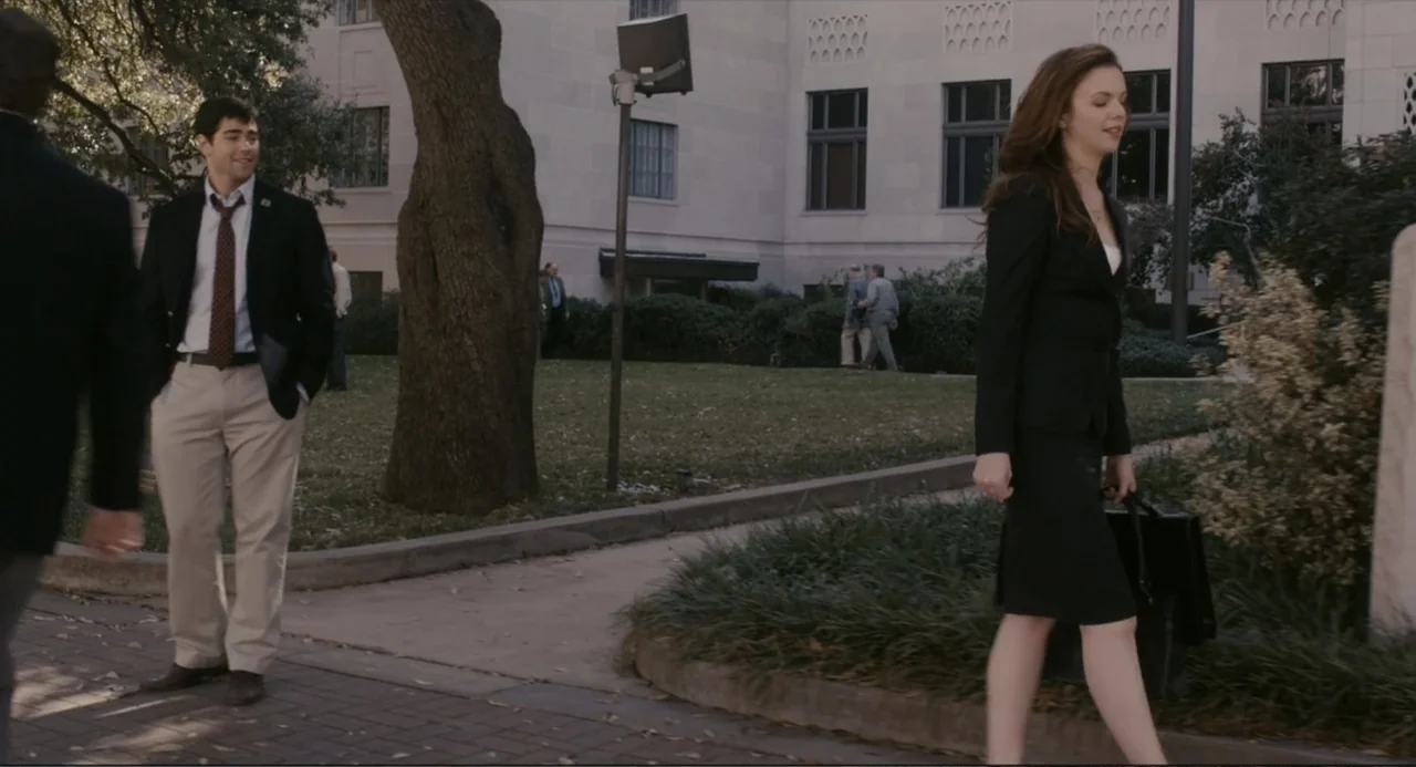 Beyond a Reasonable Doubt (2009) movie still: fullbody — A stone building with windows stands behind a grassy area with a large tree. A man in a…