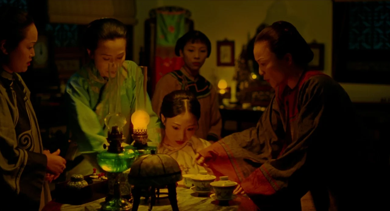 Flowers of Shanghai (1998) movie still: medium — A dimly lit room features traditional Chinese furniture and a central round wooden table. Four…