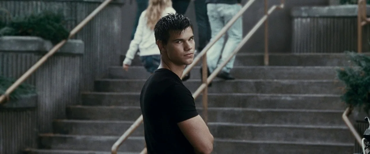 The Twilight Saga: Eclipse (2010) movie still: medium — Concrete stairs rise behind a young man standing in the foreground. Several other people…