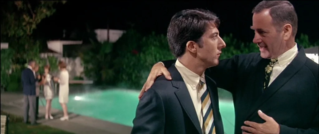 The Graduate (1967) movie still: medium — A night scene by a lit swimming pool with figures standing in the background. An older man stands with his…