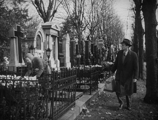 The Third Man (1949) movie still: fullbody — An outdoor cemetery features rows of old stone headstones behind wrought iron fences. A woman tends to…