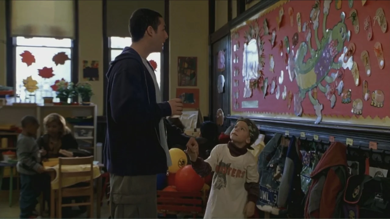 Big Daddy (1999) movie still: medium — A school room with a bulletin board decorated with paper cutouts and children's crafts. A man and a young boy…