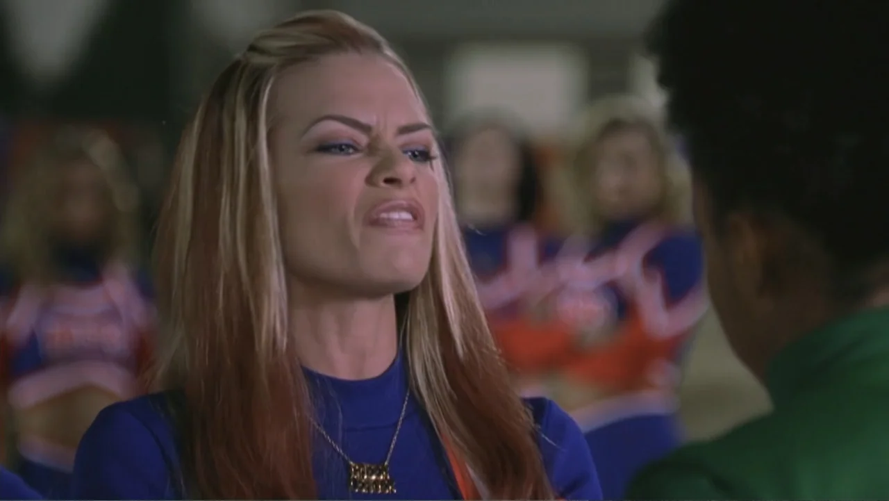 Not Another Teen Movie (2001) movie still: closeup — A cheerleader stands in a gymnasium while speaking to another person off-screen. Other…
