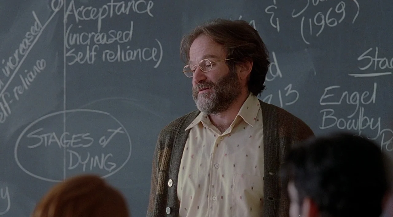 Good Will Hunting (1997) movie still: medium — A man stands in front of a slate chalkboard covered in academic notes and diagrams. He gestures…